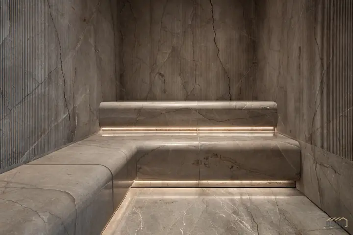 Carved stone bench with cove lighting in the wet room