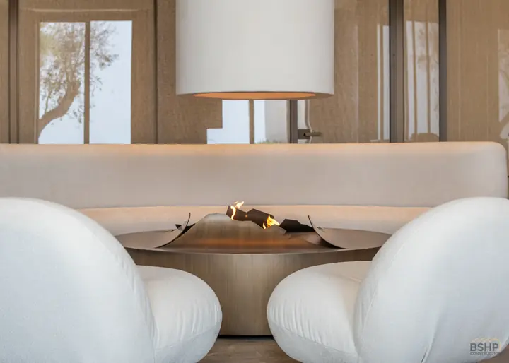 Curved banquette wrapping a bronze fire bowl in the spa lounge