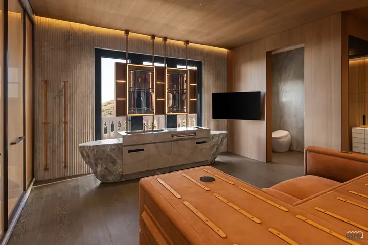 Leather-topped island and carved stone vanity in the second dressing suite