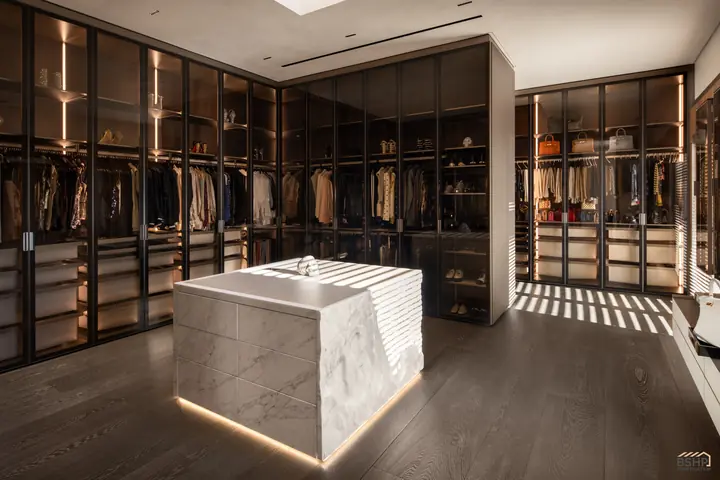 Dressing suite with glass-front wardrobes and a rippled marble island