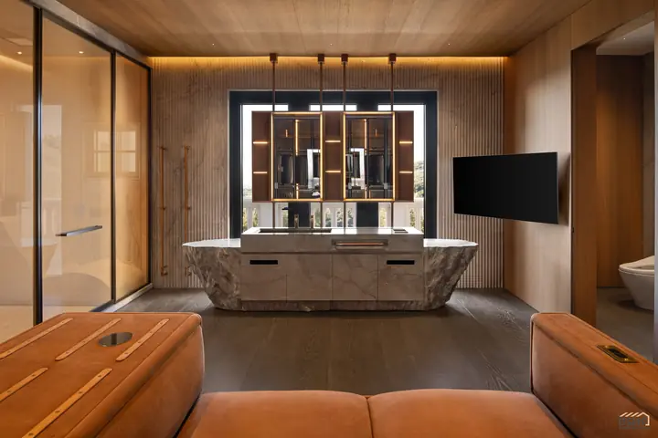 Carved stone vanity island facing the dressing suite's mirrored display wall