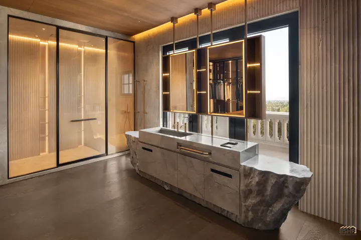 Stone vanity island with the glazed door to the bath beyond