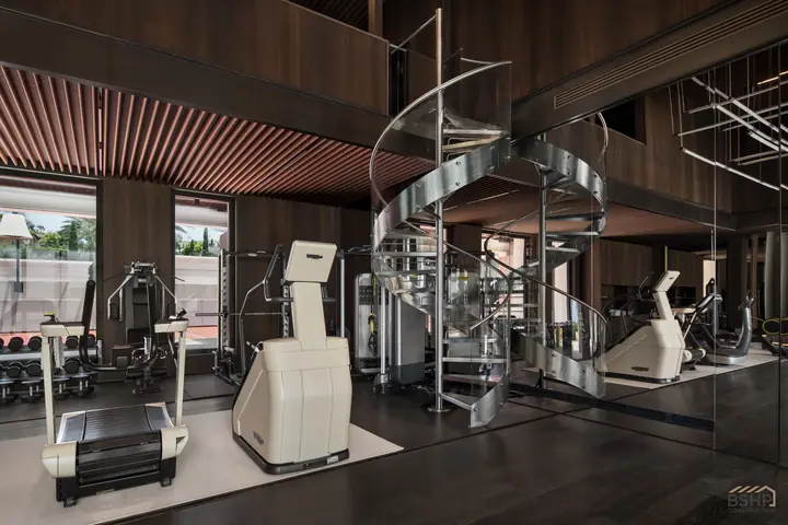 Fitness suite with mirrored wall and sculptural spiral stair