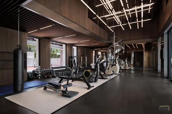 Private fitness suite with sculptural linear lighting and timber ceiling