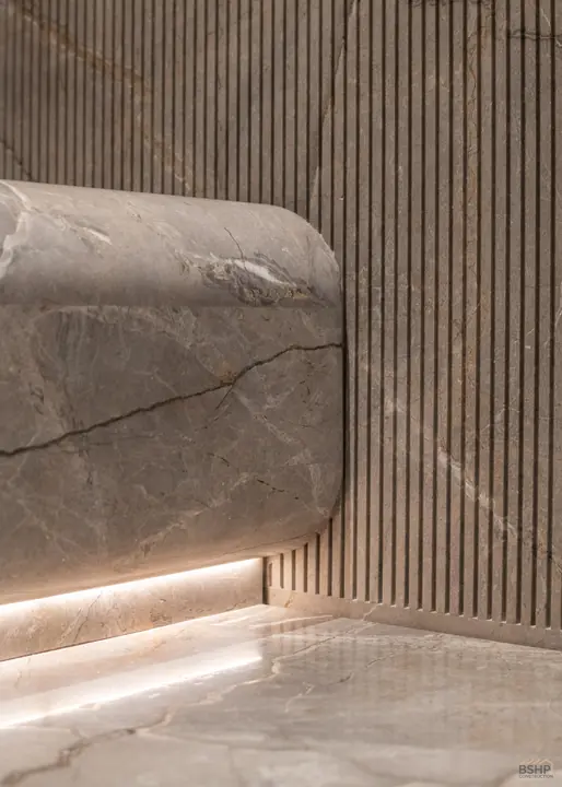 Curved marble return against fluted timber