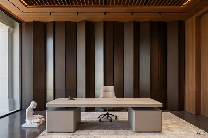 Executive desk against fluted timber panelling in the home office