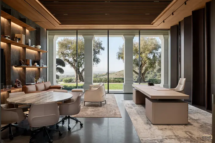 Home office opening to a colonnaded terrace, desk and meeting table in leather