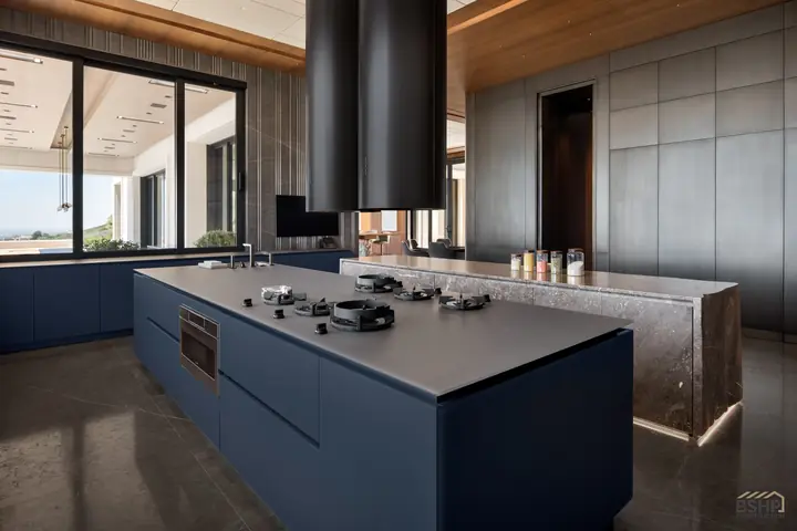 Deep blue cabinetry and stone counters in the main kitchen