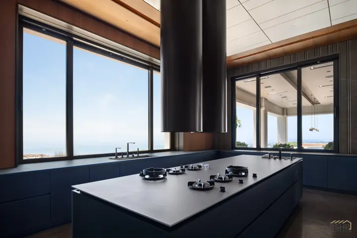 Kitchen island with integrated cooktop framing the ocean view