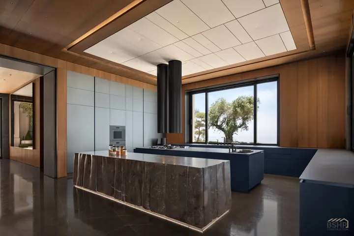 Kitchen with a monolithic stone island and lacquered cabinetry