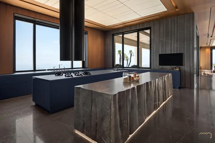 Main kitchen with twin islands and a book-matched stone waterfall