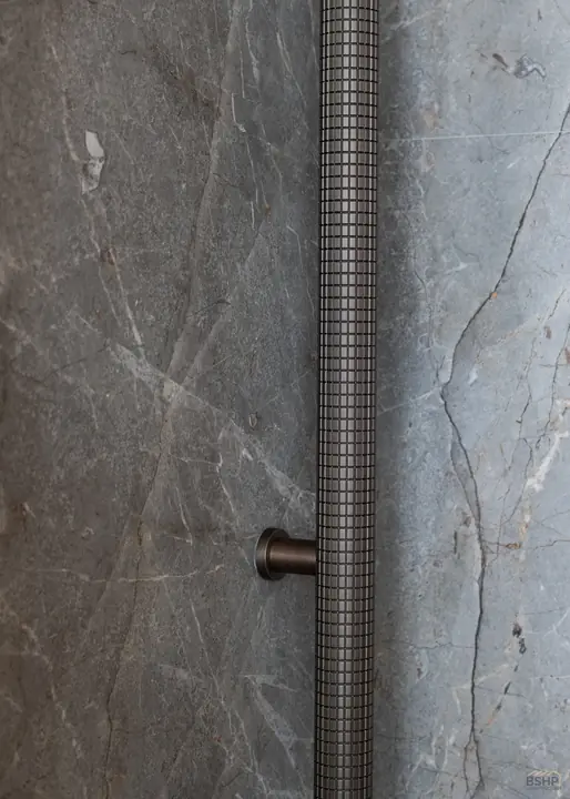 Knurled bronze pull set against book-matched stone