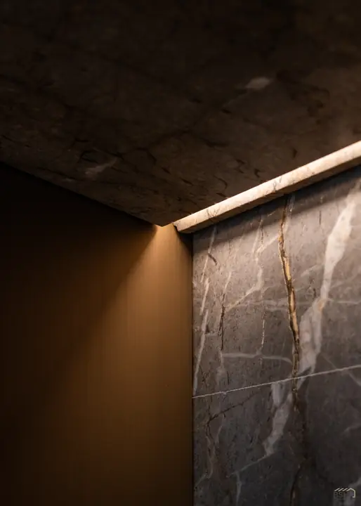 Low-lit stone corridor with a grazing light detail
