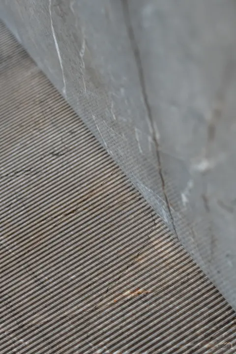 Diagonal meeting of marble and fine-reeded panelling