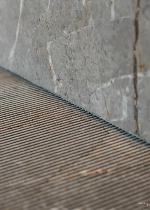 Junction of book-matched marble and reeded timber