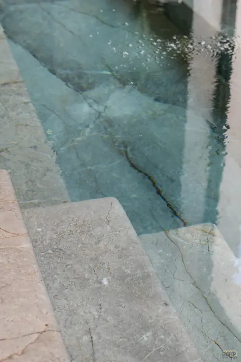 Green glass mosaic and still water in the spa pool