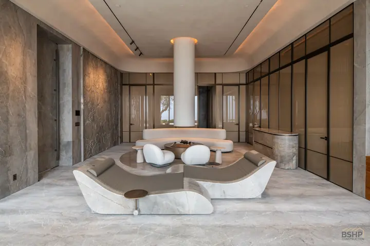 Wide view of the marble-clad spa suite with pool and lounge seating
