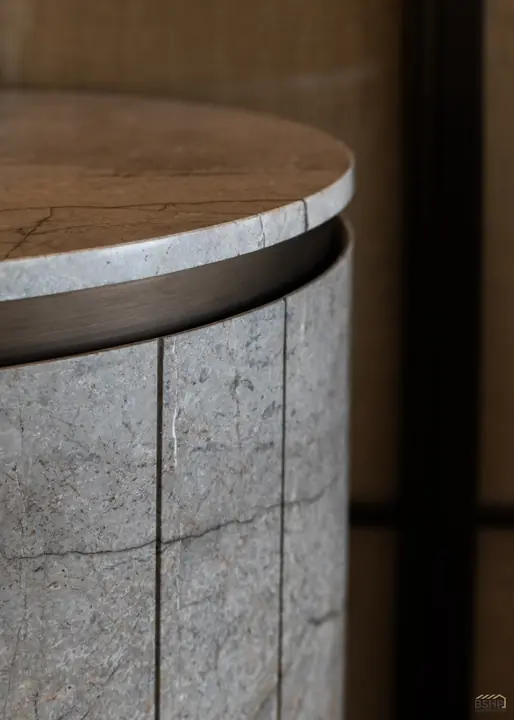 Stone-clad column detail with bronze reveal