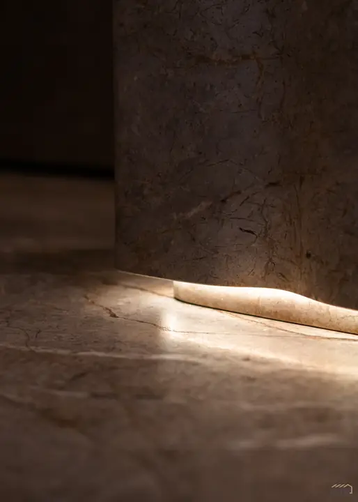 Cove lighting washing a full-height stone wall