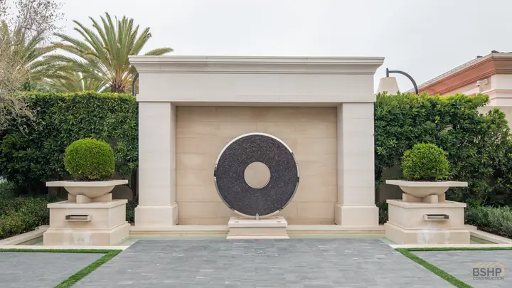 Carved stone entry monument and clipped hedging at the estate approach