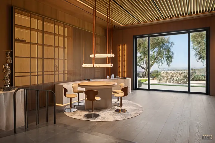 The study's bronze mesh screens and pendant lighting over the games table