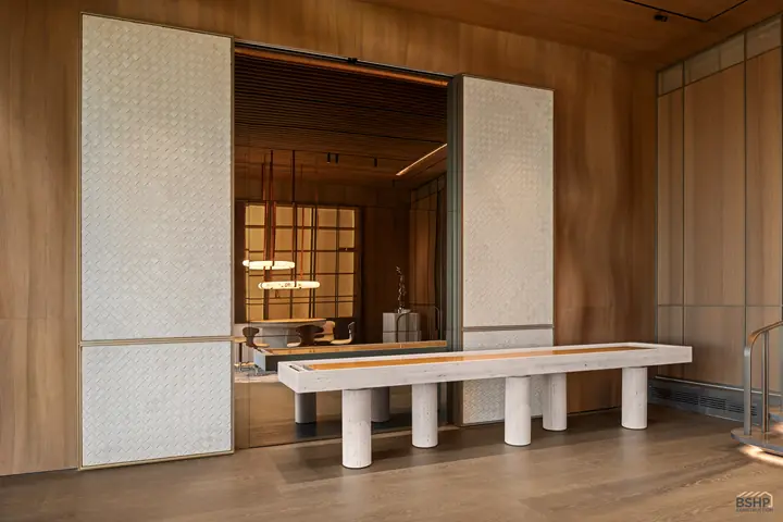 Games room with a custom shuffleboard table on a travertine base beneath a woven tile wall